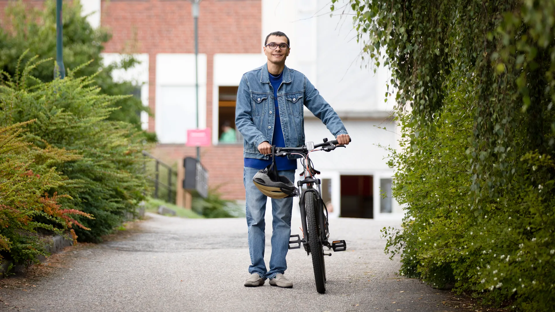 En man som står bredvid en cykel på trottoaren.
