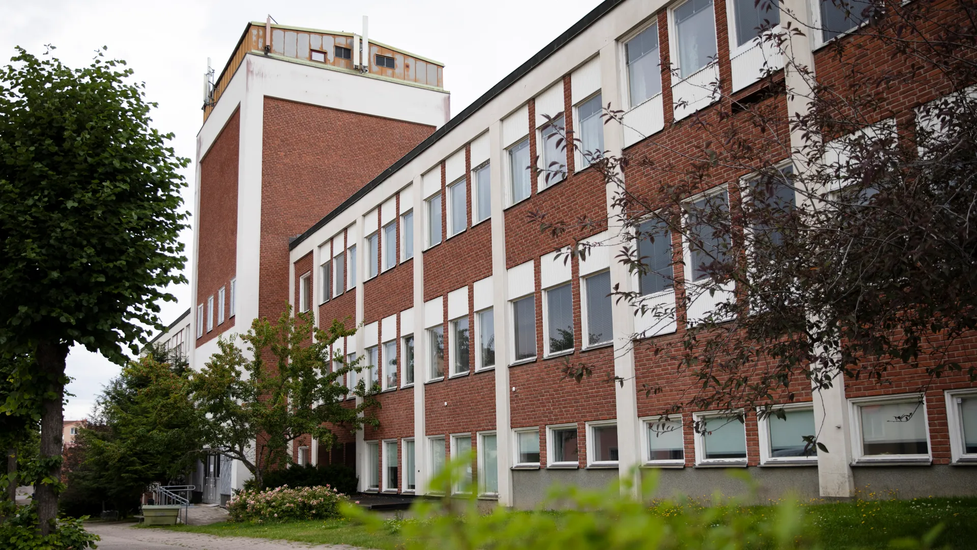 En röd tegelbyggnad med många fönster.