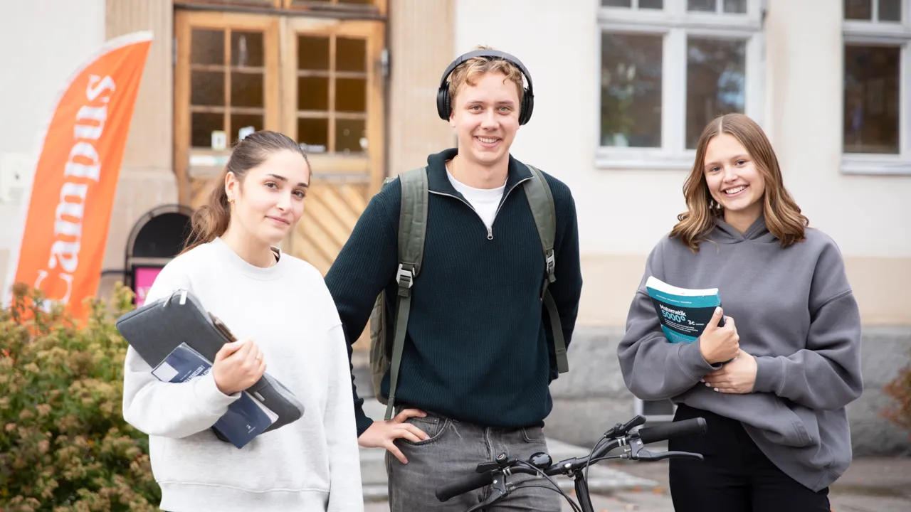 En grupp på tre personer som står bredvid varandra.