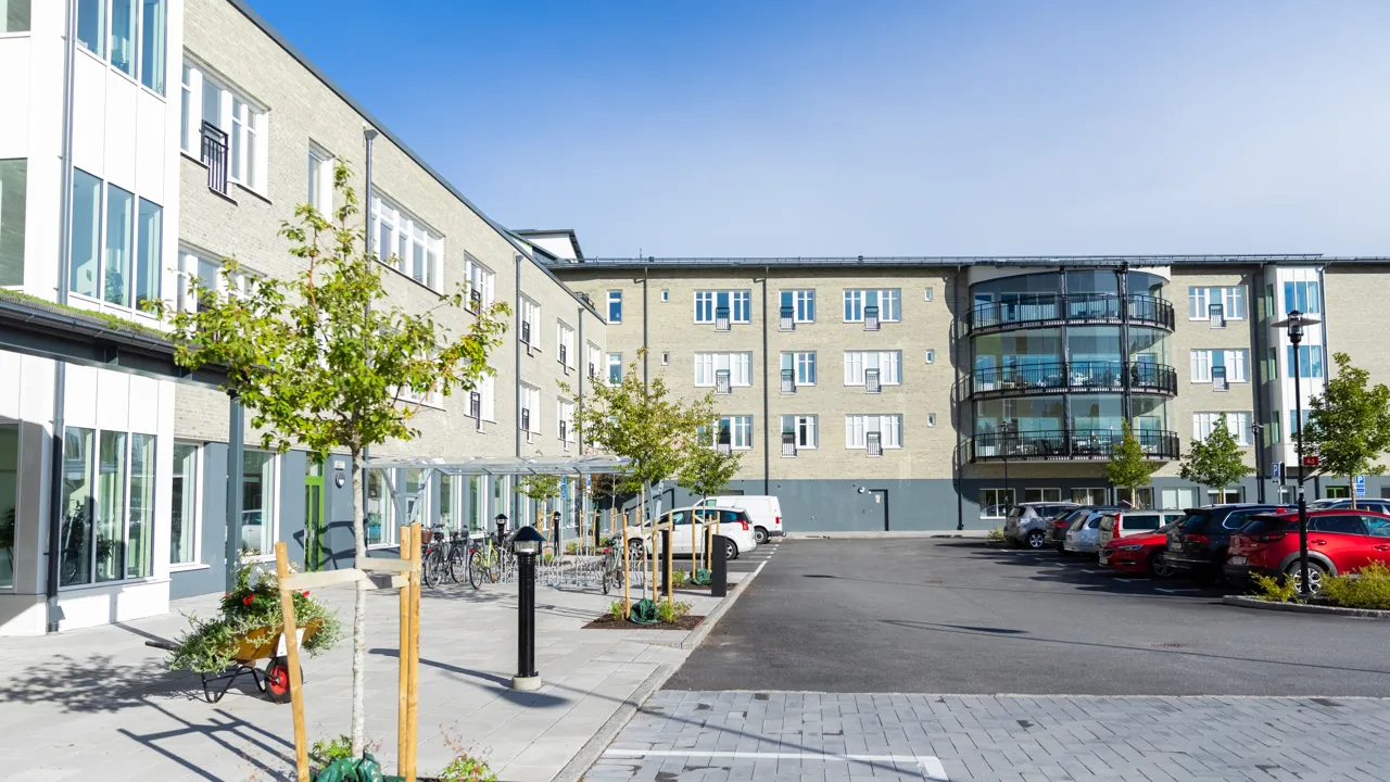 En parkeringsplats med bilar som står parkerade framför en byggnad.